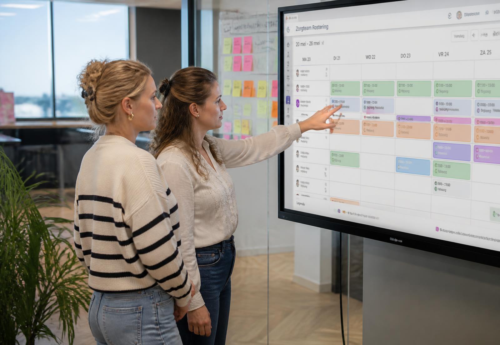 Planners bekijken samen het weekrooster van een zorgteam